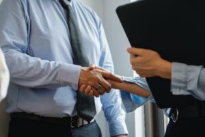 man and woman shaking hands in office